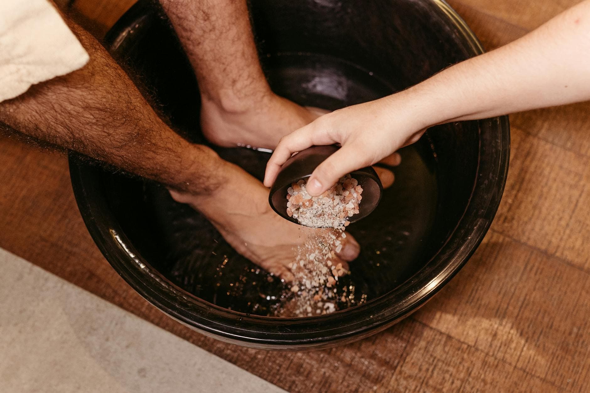 Man enjoying a soothing foot soak with Himalayan salt in a relaxing spa setting.